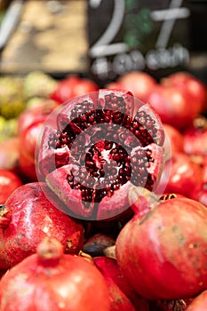 Vibrant, ruby red cracked-open pomegranate at a market