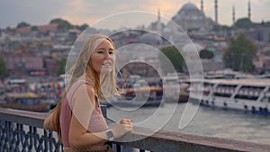 A vibrant scene unfolds as a young woman tourist savors the iconic views from Galata Bridge in Istanbul, where history