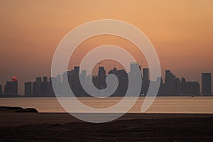 Vibrant Skyline of Doha at dramatick sunset as seen from the opposite side of the capital city bay
