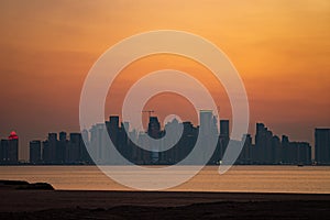 Vibrant Skyline of Doha at dramatick sunset as seen from the opposite side of the capital city bay