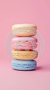 Vibrant stack of assorted macarons on a pastel pink backdrop
