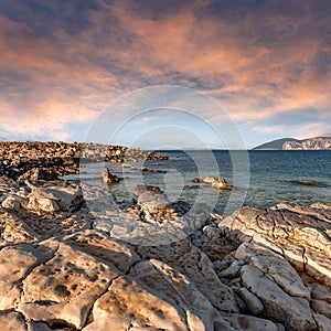 Vibrant sunset against a sunny sky over Ionian sea. Fantastic seascape with colorful sky