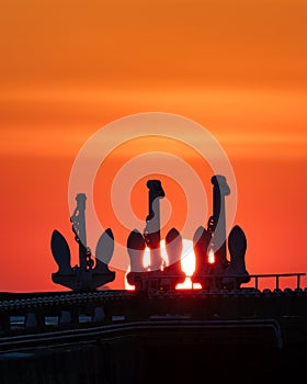 Vibrant sunset over Ontario Place marina - silhouettes of the 3 anchors of old freighters used for the breakwater photo