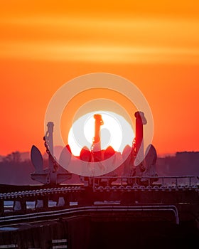 Vibrant sunset over Ontario Place marina in Toronto with silhouettes of the 3 anchors of decommissioned old Great Lakes freighters photo