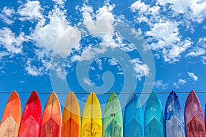 Vibrant surfboards under blue sky, representing summer beach vacation and leisure activities