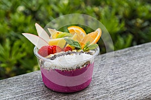 Vibrant takeaway acai bowl with fresh fruit and mint