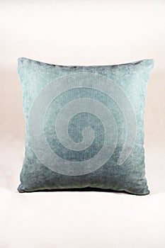 Vibrant teal pillow on a white velvet background