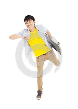 Vibrant young man holding a skateboard and make a pose