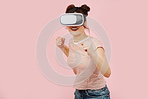 Vibrant young woman full of energy in VR headset assumed combat stance.