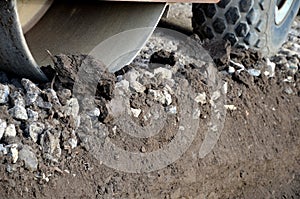 The vibrating roller compresses the aggregate and concrete gravel fragments. it can also roll asphalt. close-up view of a tire and