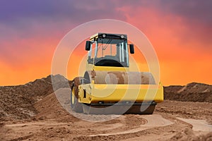 Vibration single-cylinder road roller on amazing sunset background. Soil Compactor for leveling ground for the foundation and on