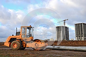 Vibration single-cylinder road roller leveling the ground for the construct of the foundation for residential building, office,