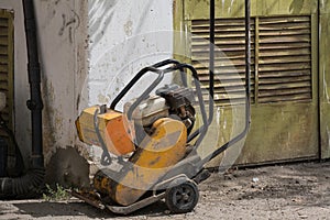 Vibratory plate compactor compacting asphalt at road repair