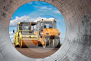 Vibratory road roller lays asphalt on a new road under construction. Close-up of the work of road construction equipment. Modern