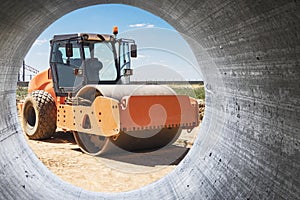 Vibratory road roller lays asphalt on a new road under construction. Close-up of the work of road construction equipment. Modern