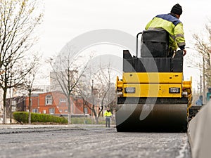 The vibratory roller levels the asphalt pavement