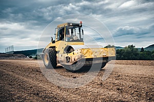 Vibratory soil compactor working on highway construction site