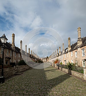 Vicars` Close, in Wells, Somerset UK. Street of medieval terraced houses with iconic chimneys behind Wells Cathedral.