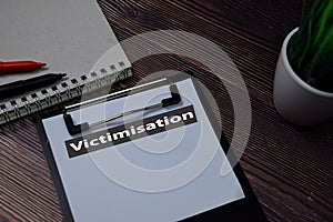 Victimisation write on paperwork isolated on wooden table