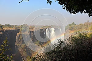 Victoria falls with rainbow during dry season on holiday with sambesi river in zambia.