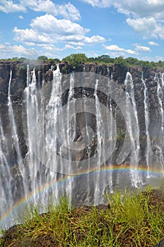 Victoria Falls with rainbow on Zambezi River, view from Zimbabwe, Africa