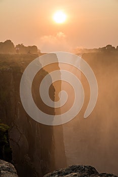 Victoria Falls sunset with tourist in the cliff