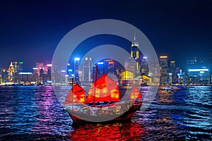 Victoria Harbour with junk ship at night in Hong Kong