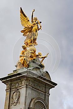 Victoria memorial London, Victory statue, angel of peace, England. People waiting in front of gates of Buckingham Palace