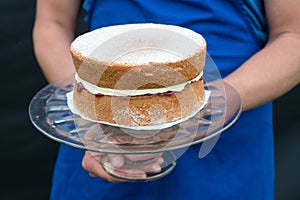 A victoria sponge cake on glass cake stand