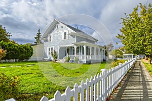 A Victorian cottage with a white picket fence and covered front porch and deck in the Spokane, Washington area of the U.S.