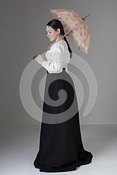 A Victorian or Edwardian woman wearing a white linen garibaldi blouse and black skirt