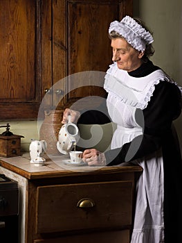 Victorian kitchen maid pouring tea