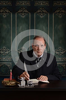 Victorian office worker dipping quill in ink pot