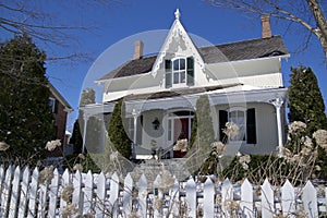 Victorian style house with the white picket fence in winter