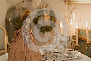 A Victorian Teapot Doll With The Porcelain Set Serving Tea On The Table