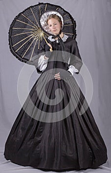 Victorian woman in a black bodice, skirt, parasol and bonnet photo