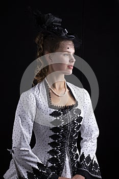 Victorian woman in black and white bustle dress and hat