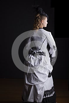 Victorian woman in black and white bustle dress and hat