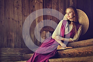 Victorian Woman Portrait. Dreaming Country Side Romantic Beauty Girl over dark wooden Background Copy Space. Outside Fashion