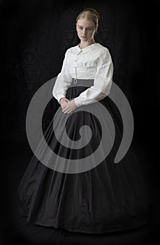 A Victorian woman with a tortoise shell comb in her hair stands against a dark backdrop.