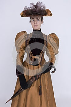 A Victorian woman wearing a bronze and brown silk ensemble