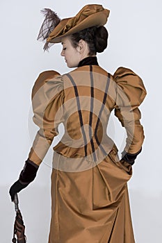 A Victorian woman wearing a bronze and brown silk ensemble photo