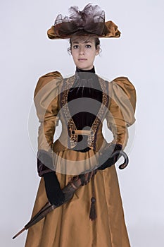 A Victorian woman wearing a bronze and brown silk ensemble photo