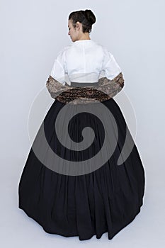 A Victorian woman wearing a white Garibaldi blouse and full, black skirt with a paisley shawl