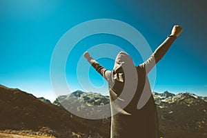 Victorious female person on mountain top.