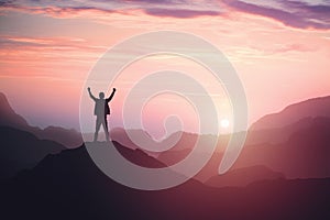 Victorious male person standing on mountain top with arms raised. Winning and success