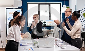 Victorious overjoyed diverse team of businesspeople clapping