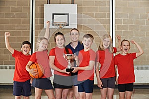 Victorious School Sports Team With Trophy In Gym