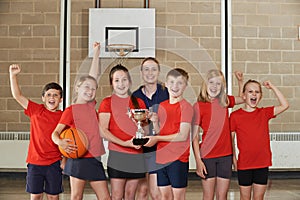 Victorious School Sports Team With Trophy In Gym photo