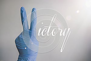 Victory concept image after the covid19 pandemic outbreak. Coronavirus defeated. Hands with medical gloves showing a V sign for vi